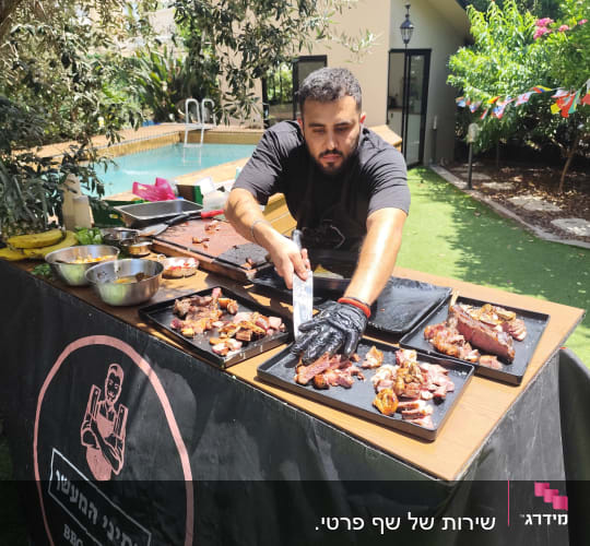 שף מכין בשר על גריל בחצר עם בריכה